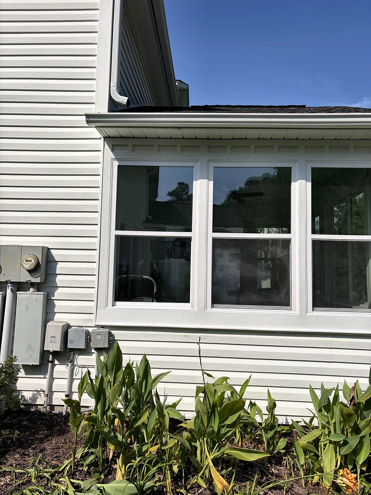 Sunroom exterior window wall above garden
