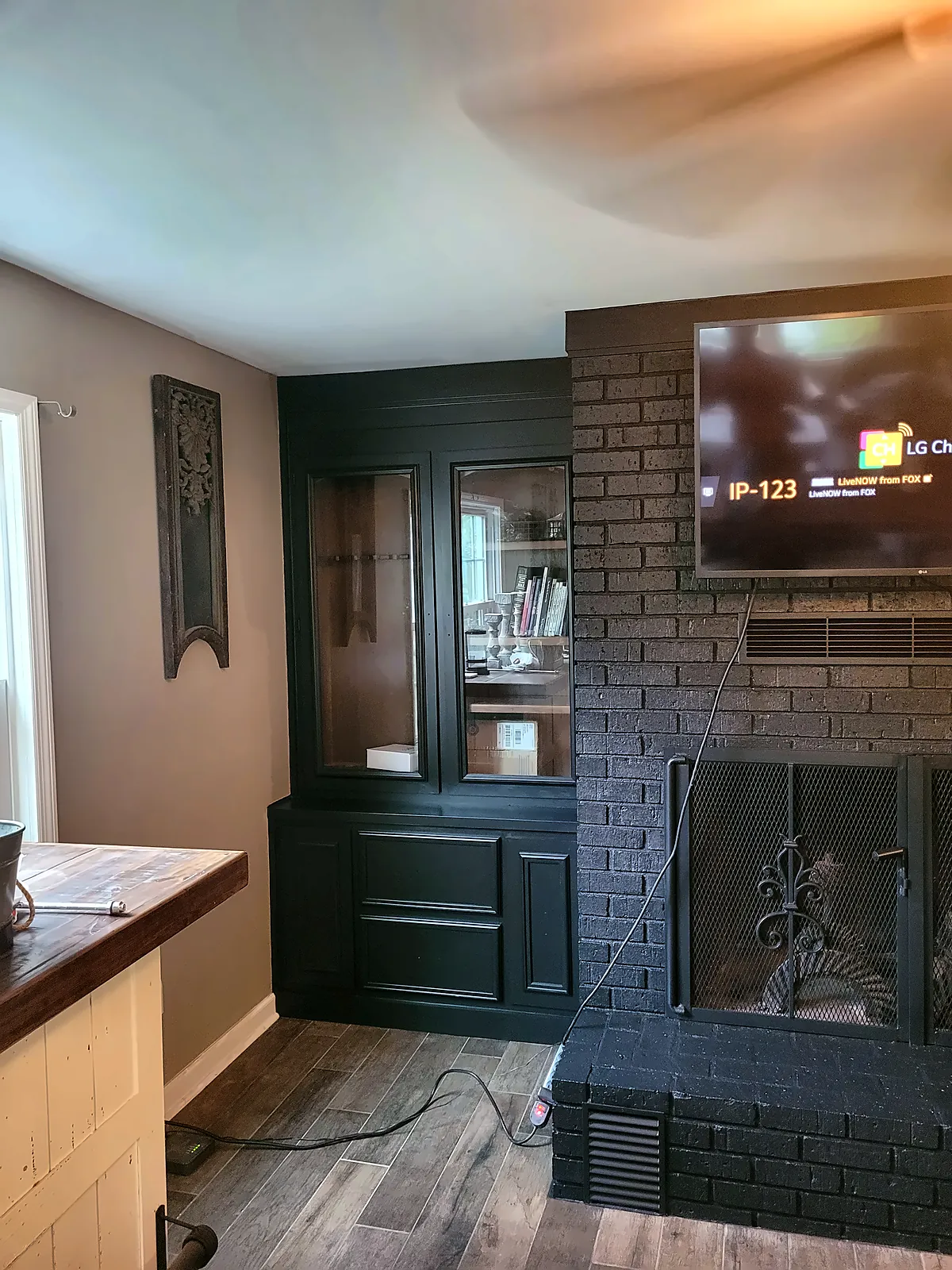 Brick fireplace and built-ins painted dark charcoal after makeover