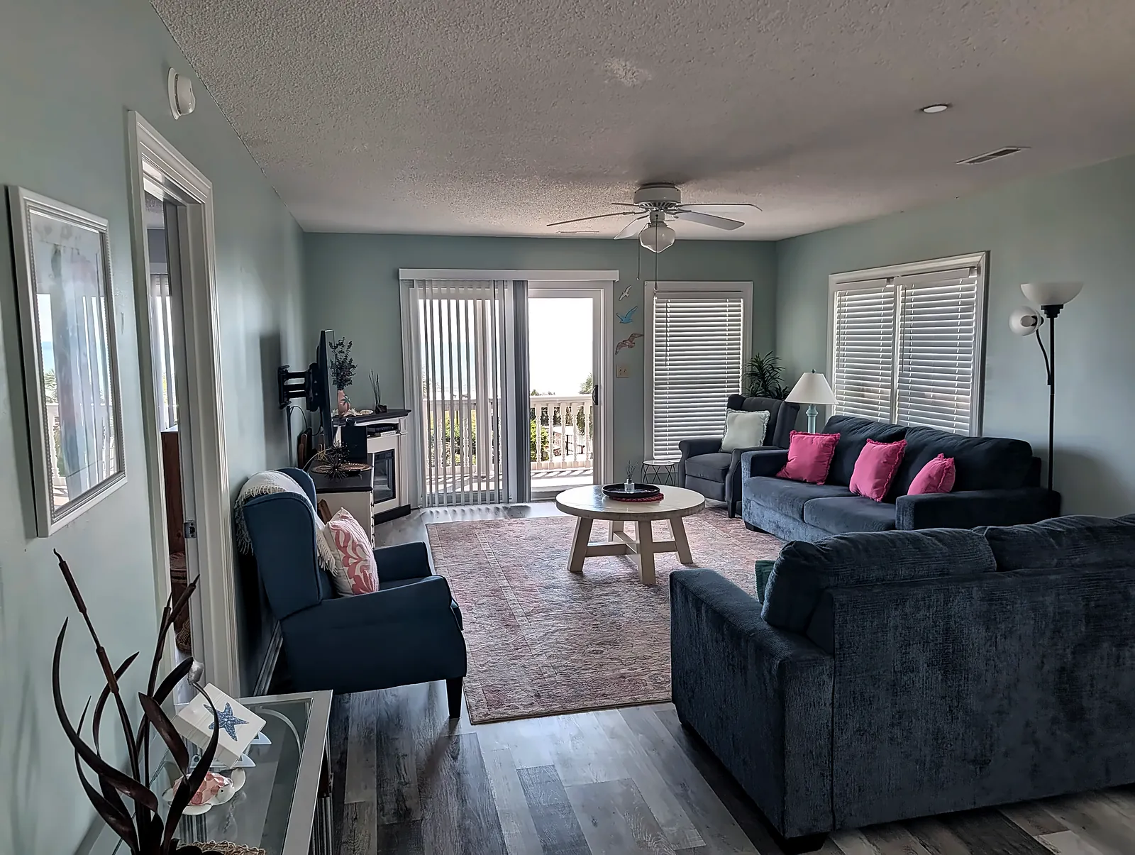 Coastal condo living room with wood-look floors and sliding doors