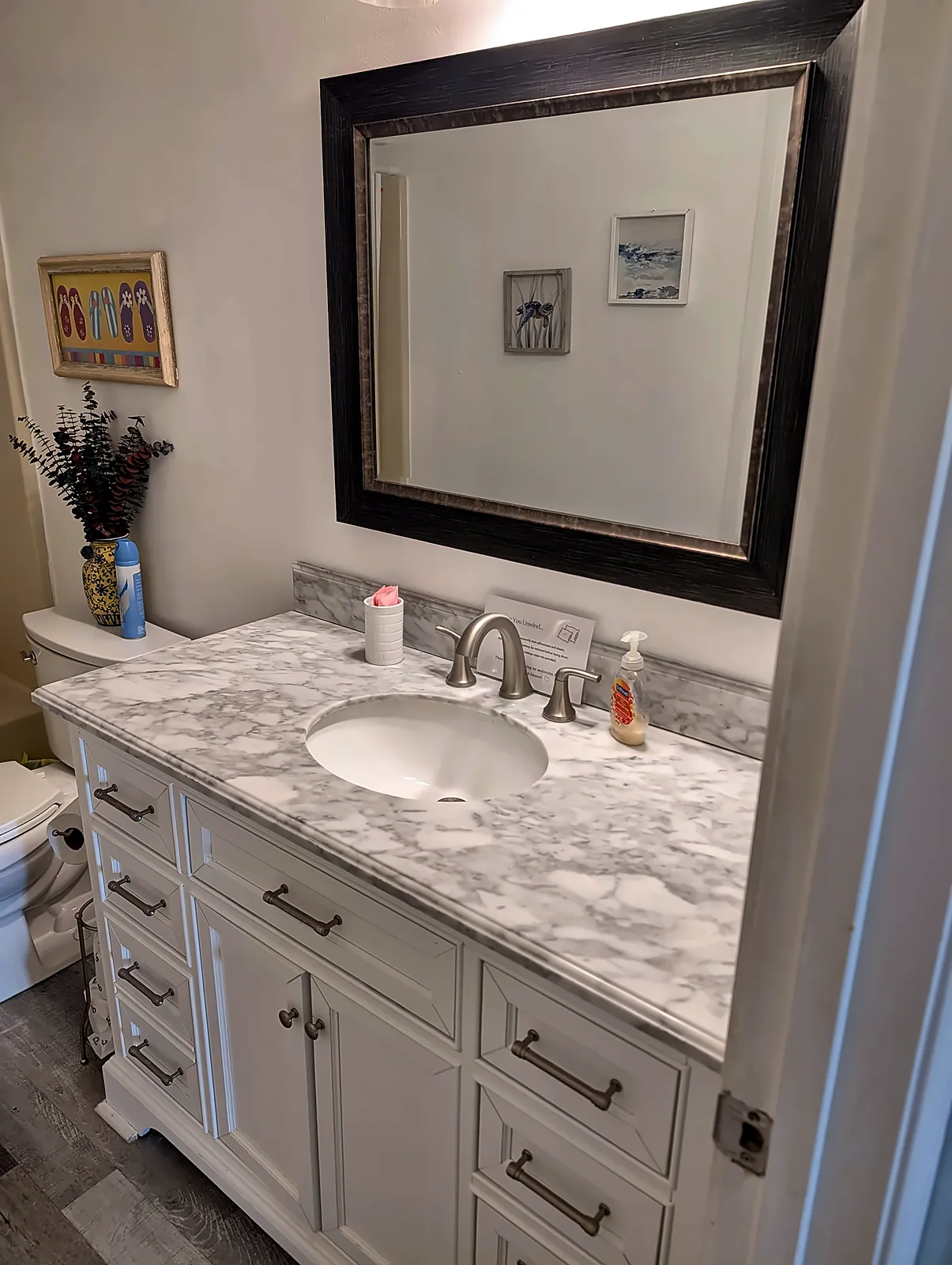 Bathroom vanity with marble-look top and framed mirror