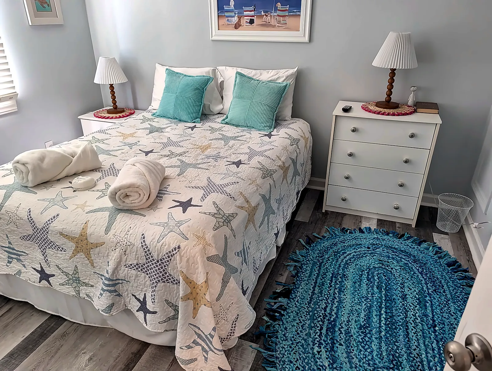 Coastal guest bedroom with wood-look floor