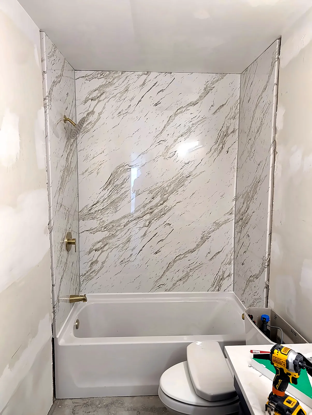 Bathroom with marble-look tub surround and new fixtures