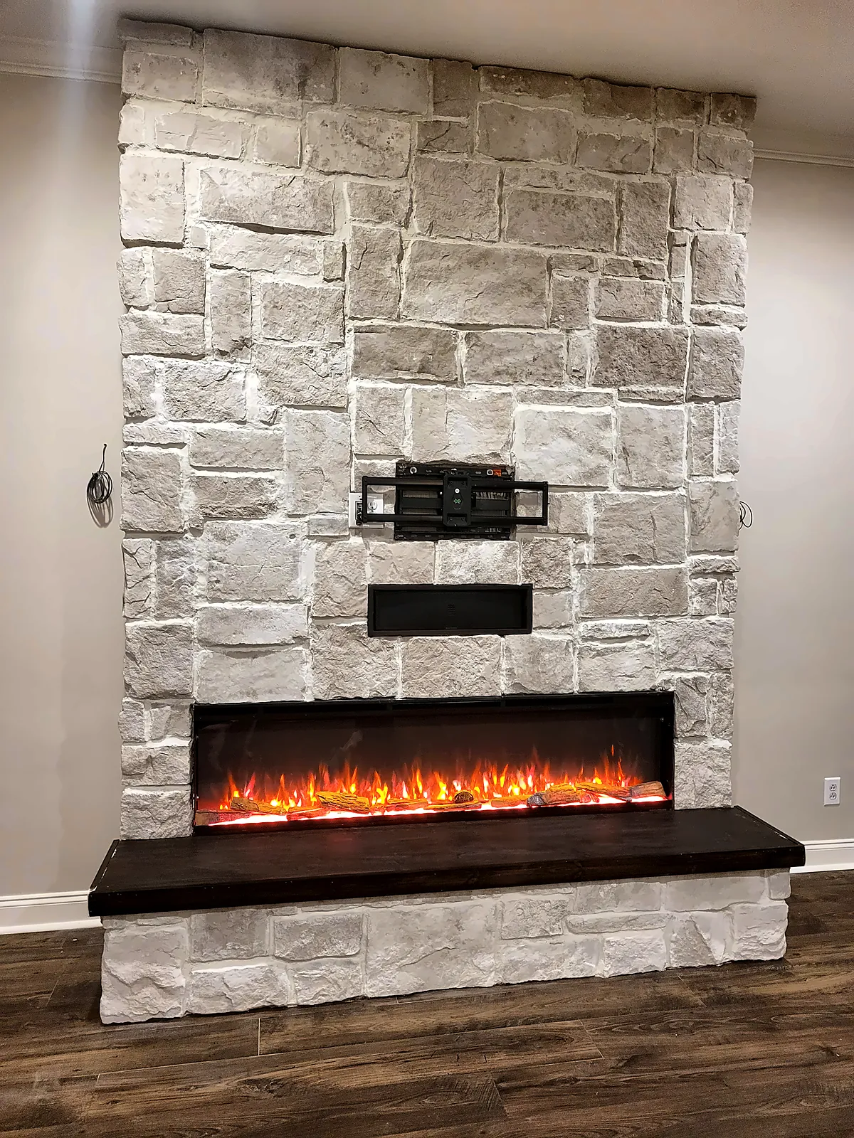 Whitewashed stone fireplace feature wall with dark hearth