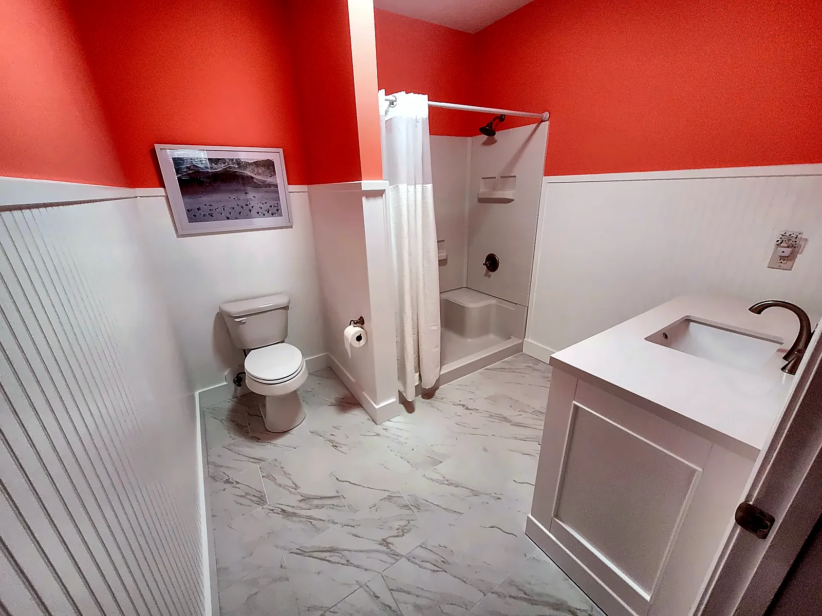 Guest bathroom with beadboard wainscot and marble-look tile floor