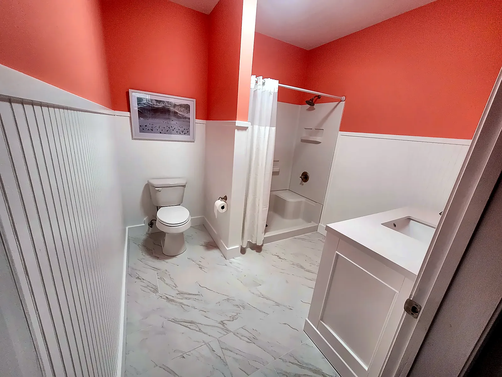 Renovated guest bath with wainscot, vanity and tub