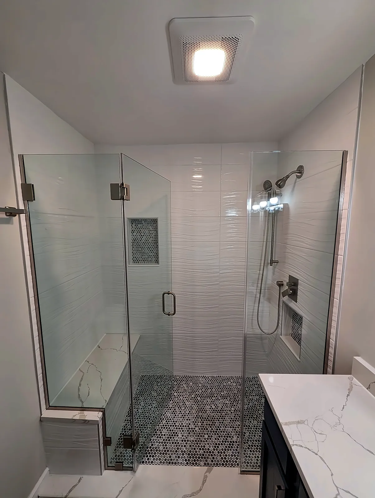 Walk-in glass shower with niche and bench