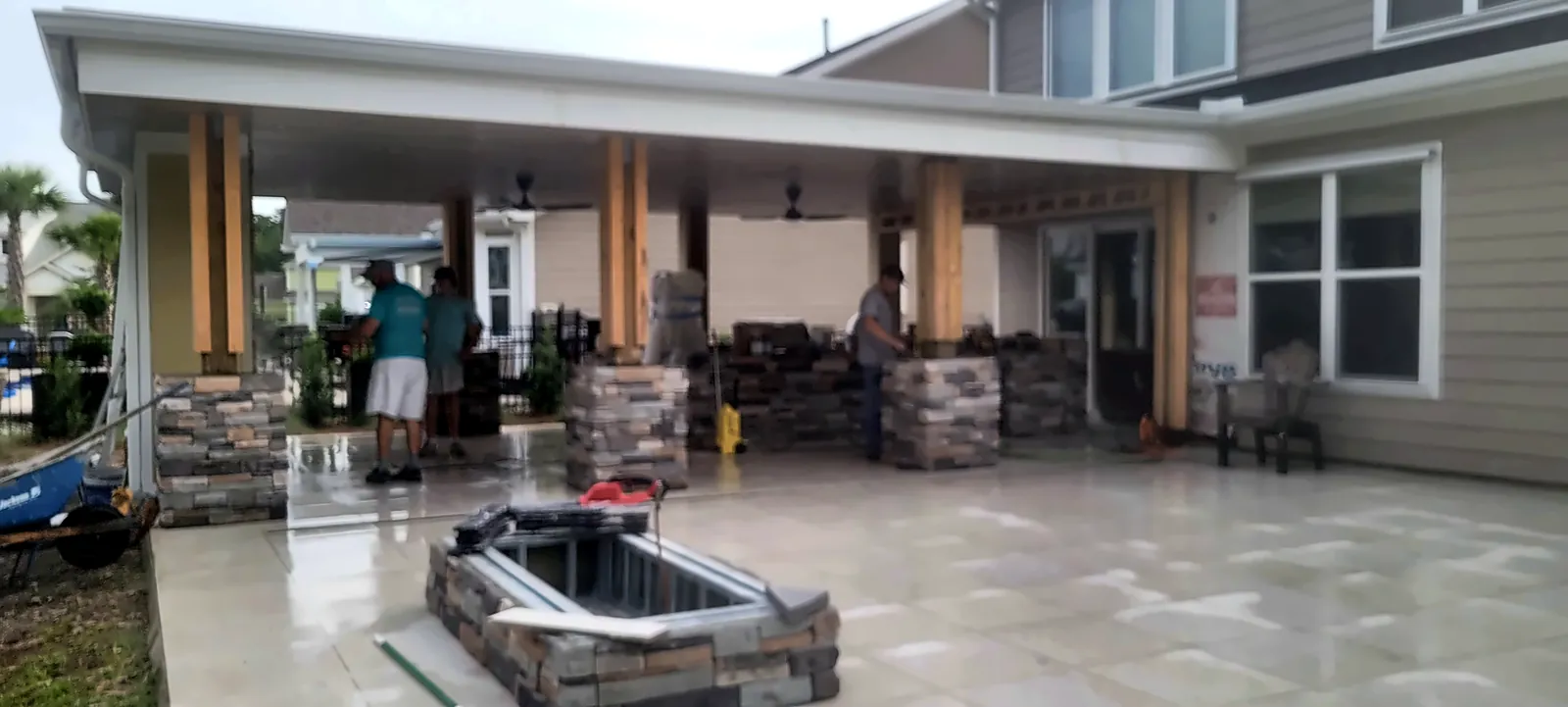 Covered patio with stone fire feature and outdoor kitchen island
