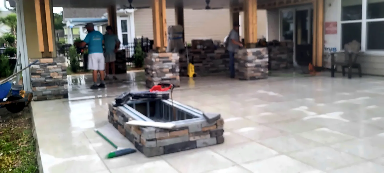 Stone-clad outdoor kitchen island under covered patio