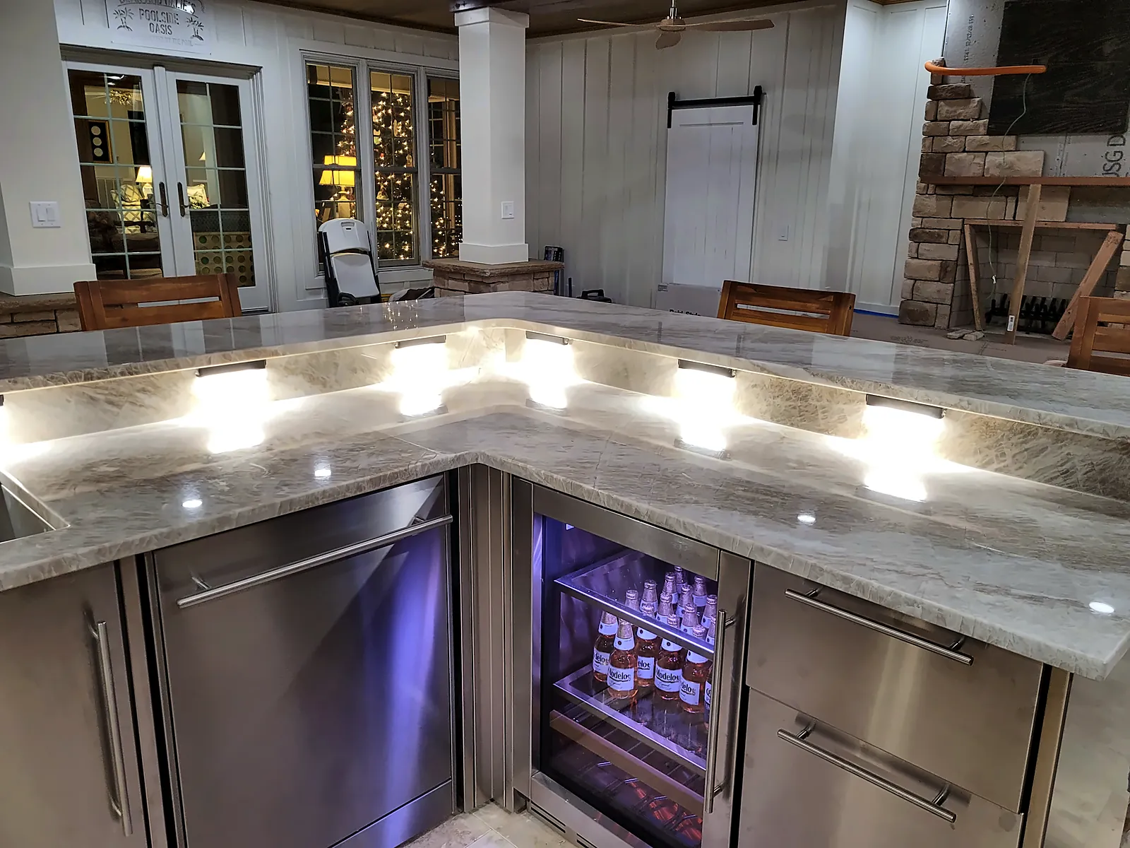Stainless outdoor kitchen with beverage fridges and illuminated stone countertop – Outdoor Living