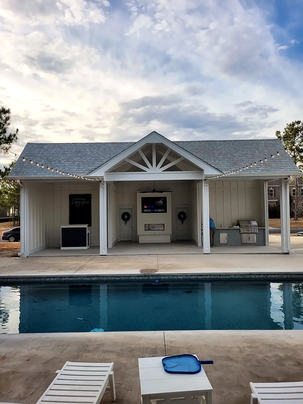 Pool house with sunburst gable under blue sky – New Construction