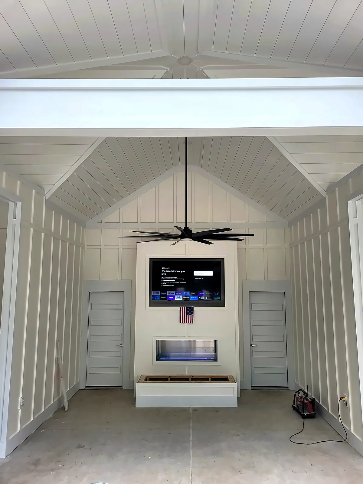 Vaulted board-and-batten cabana interior with fireplace media wall