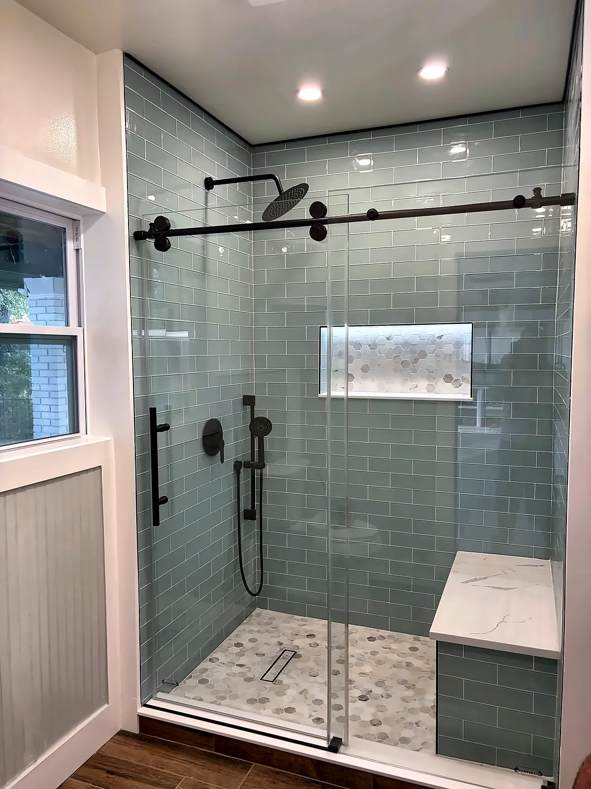 Walk-in shower with sea-glass subway tile, black fixtures and sliding glass door – Kitchens & Baths