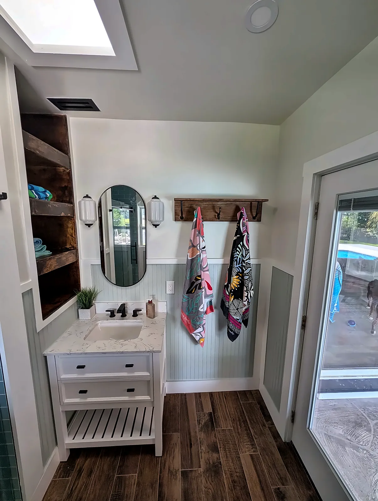 Coastal bathroom with beadboard wainscot, vanity and wood-look floor