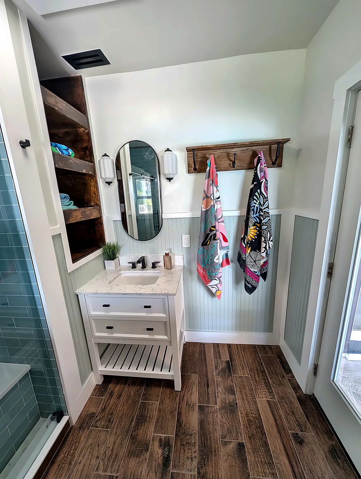 Bathroom vanity and towel hooks with skylight above