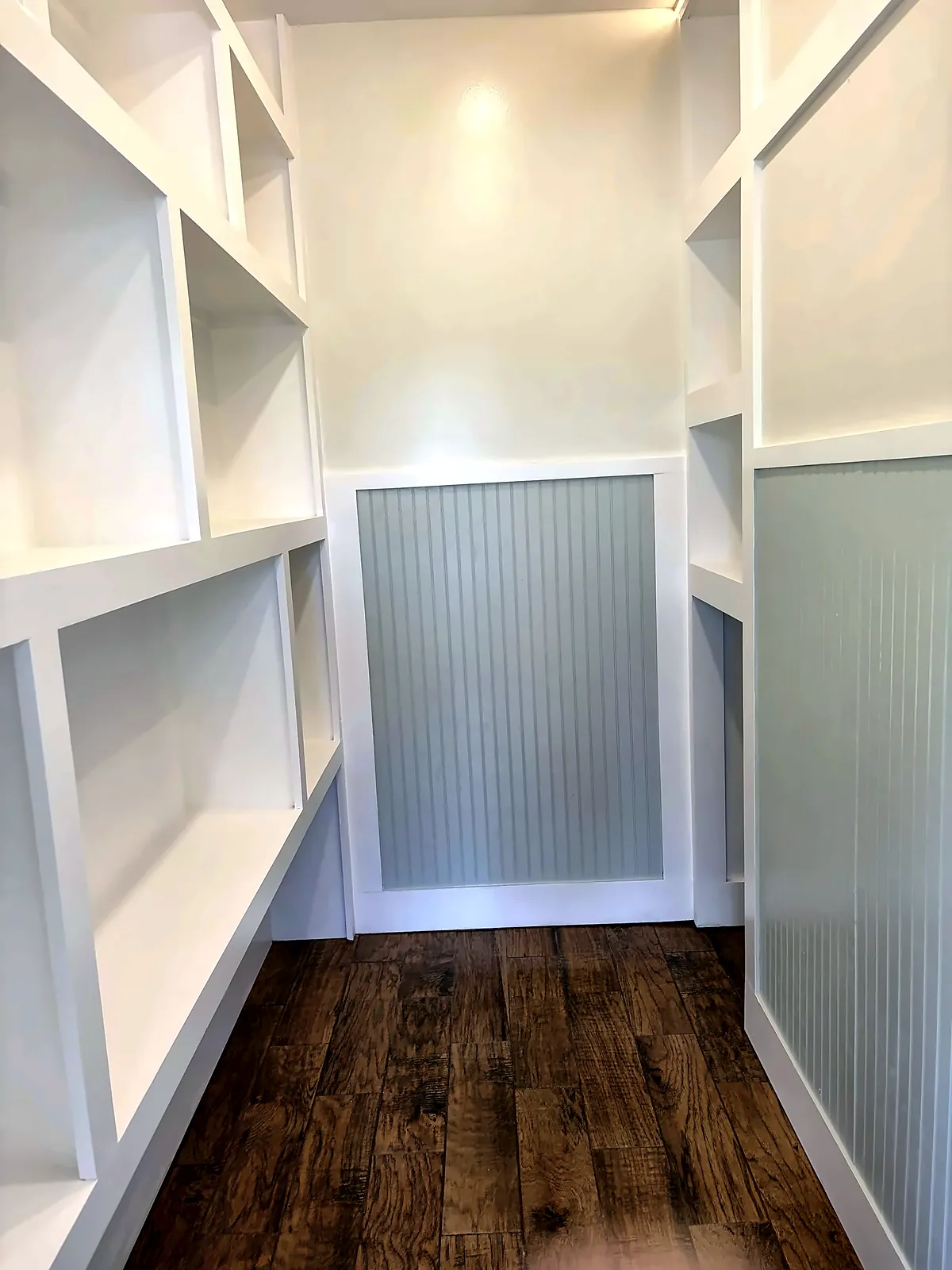 Custom walk-in closet with built-ins and wood-look tile floor