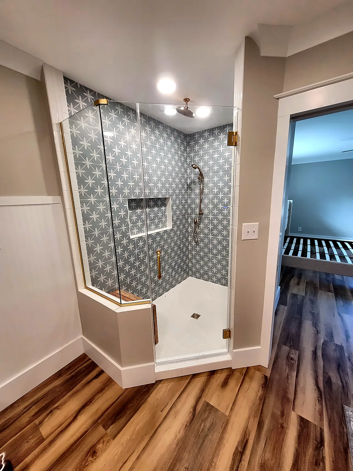 Frameless glass shower with patterned tile and wainscot walls