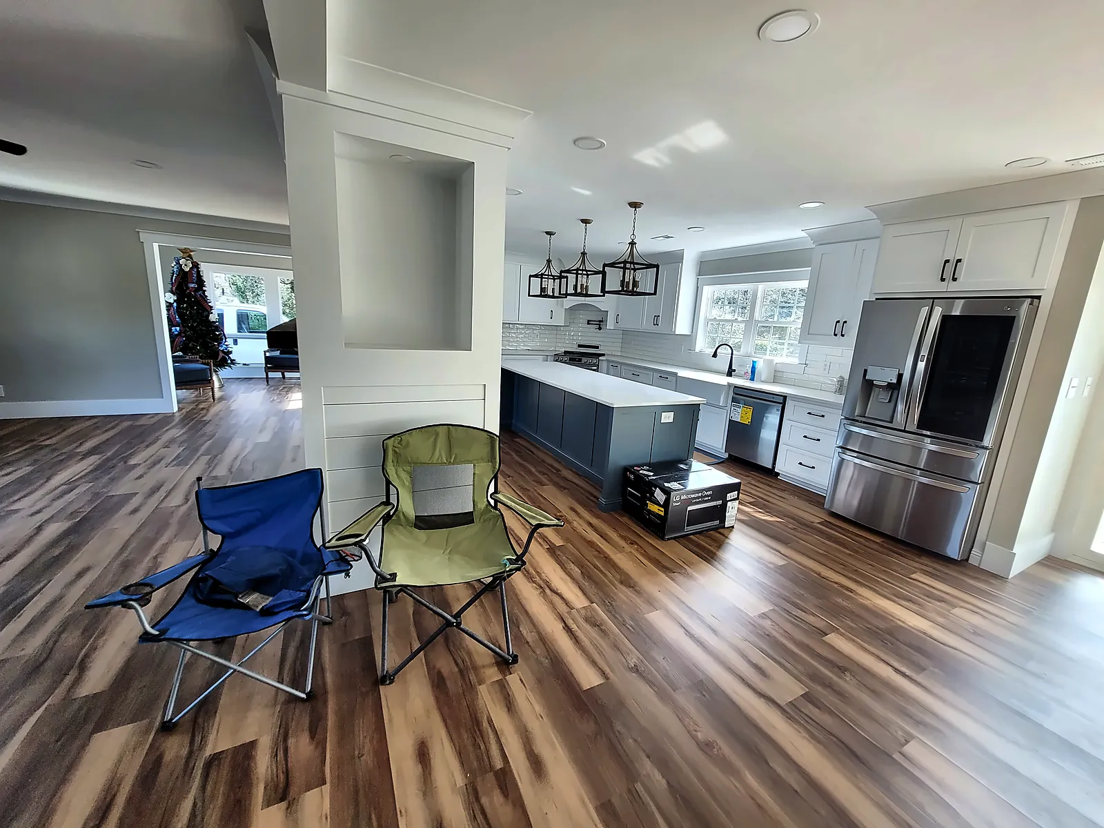 Open kitchen with island and stainless refrigerator after renovation
