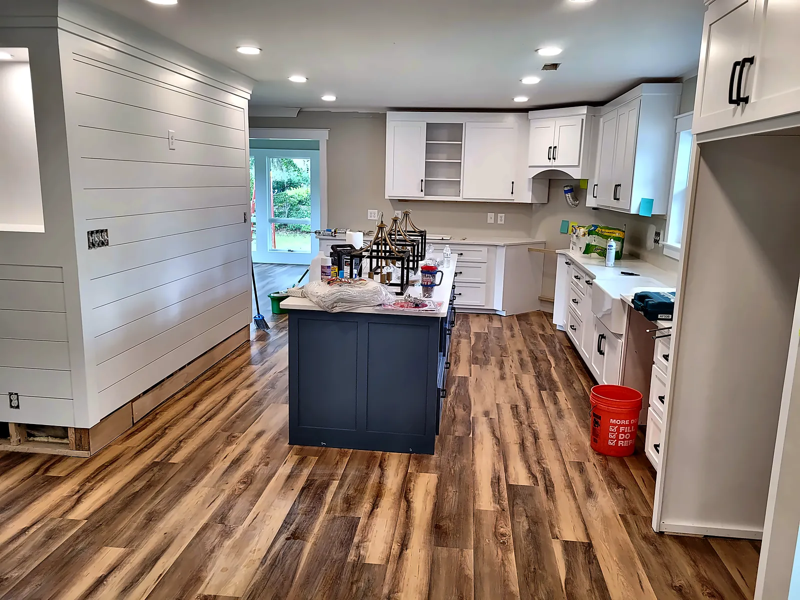 Renovated kitchen with white cabinets and dark island