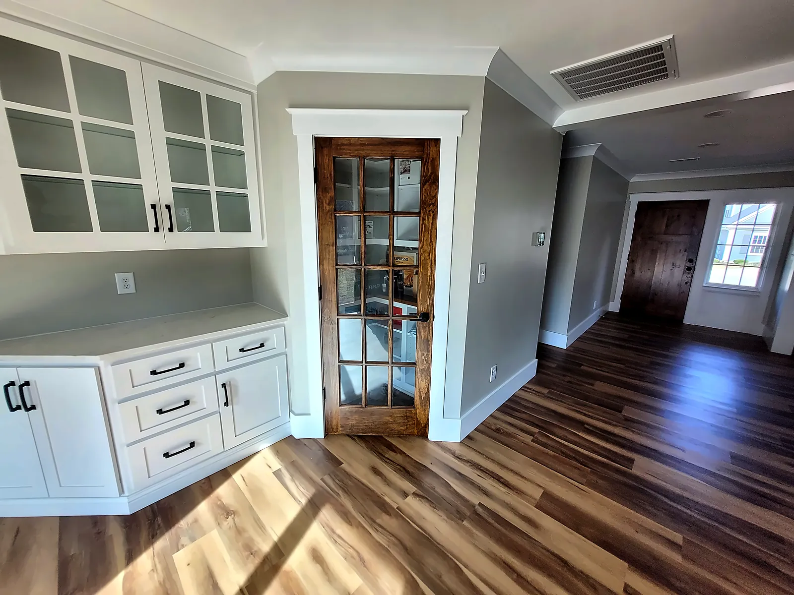 Built-in cabinetry and glass-panel door in renovated hallway