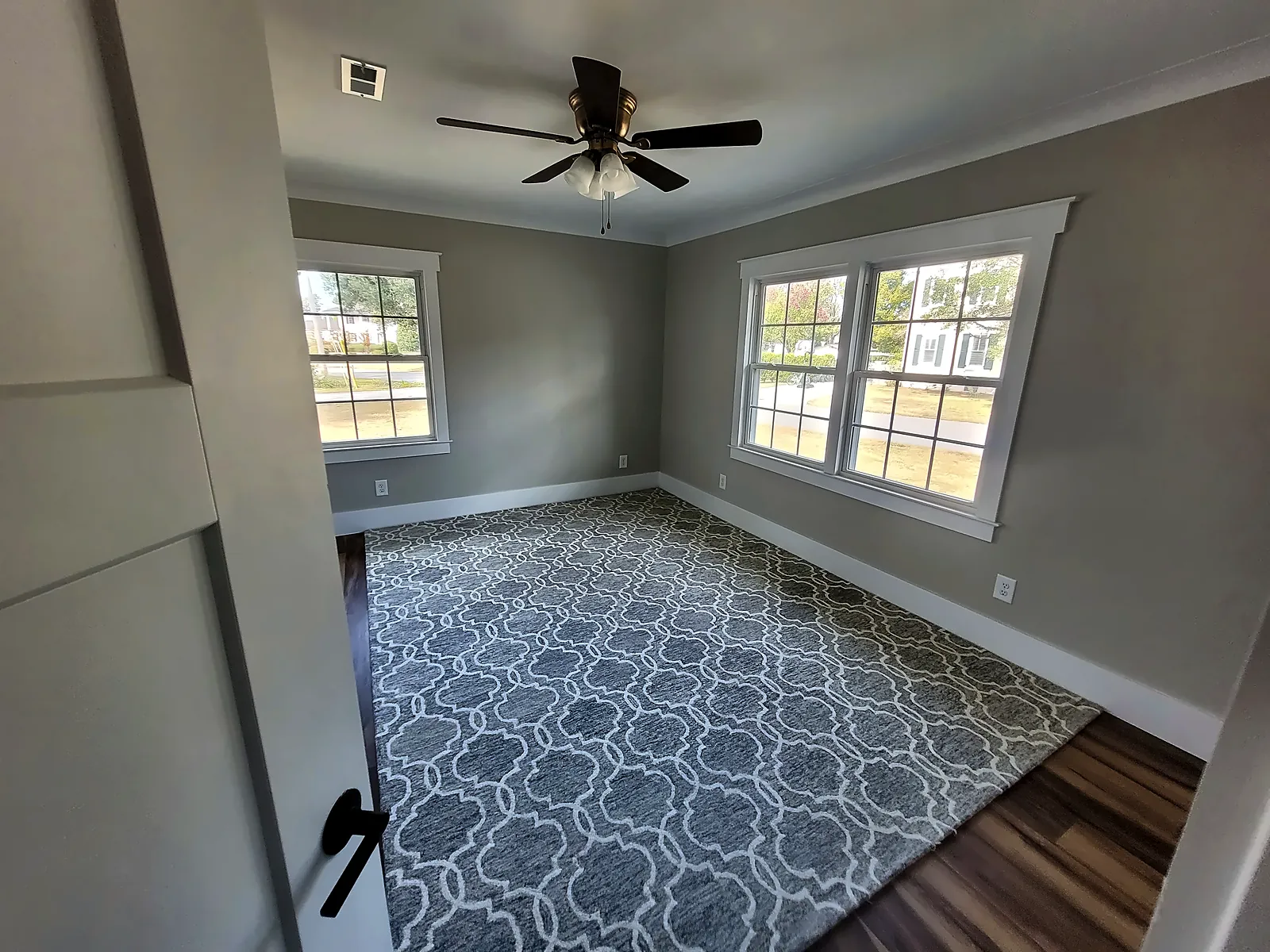 Renovated bedroom with new flooring and ceiling fan