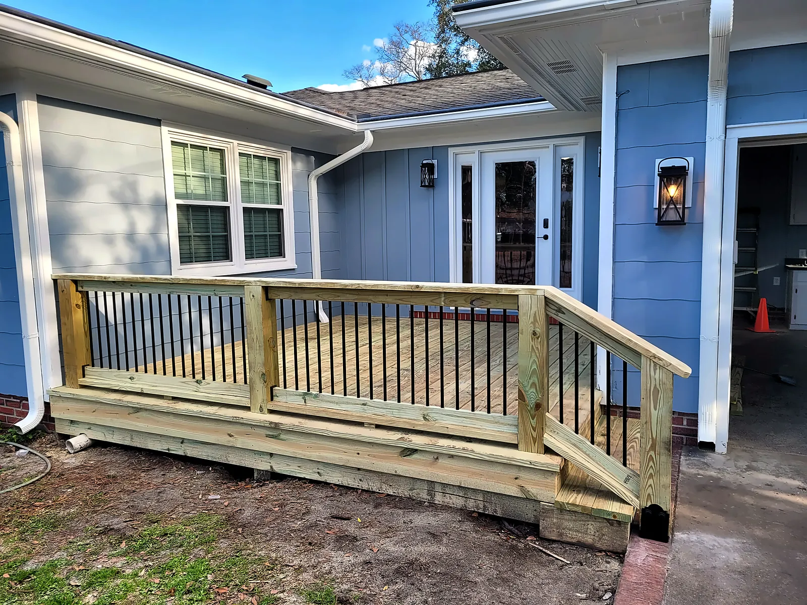 New wood deck with black balusters and steps