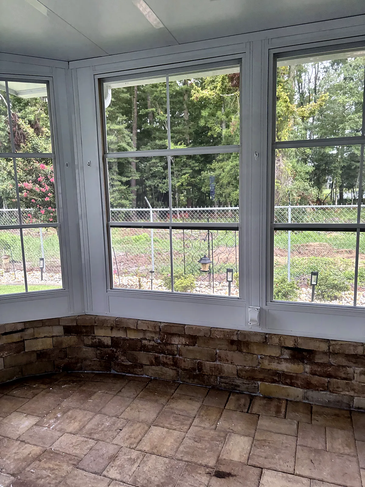 Sunroom with stacked-stone knee wall and continuous windows