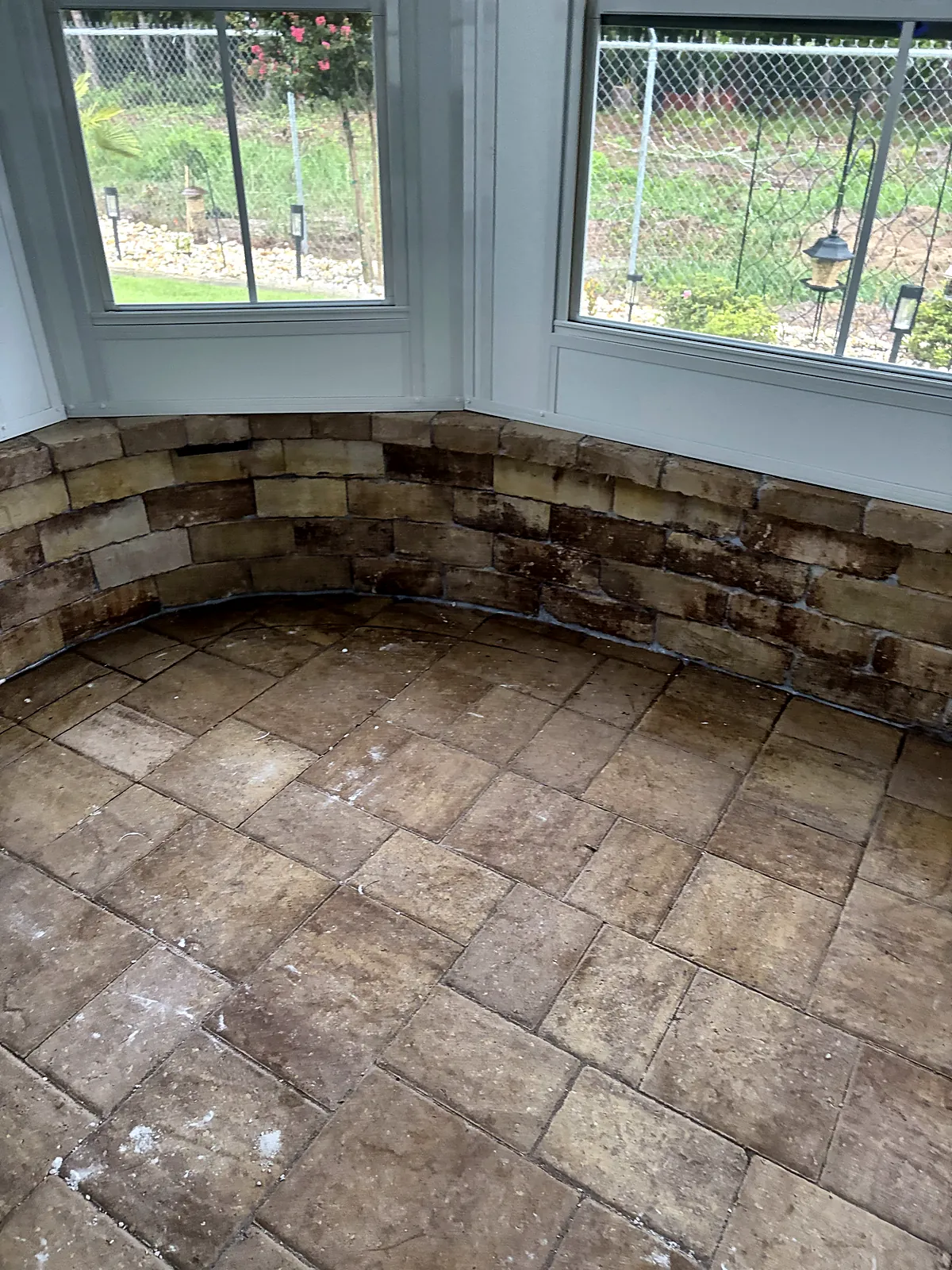 Curved stacked-stone knee wall in sunroom