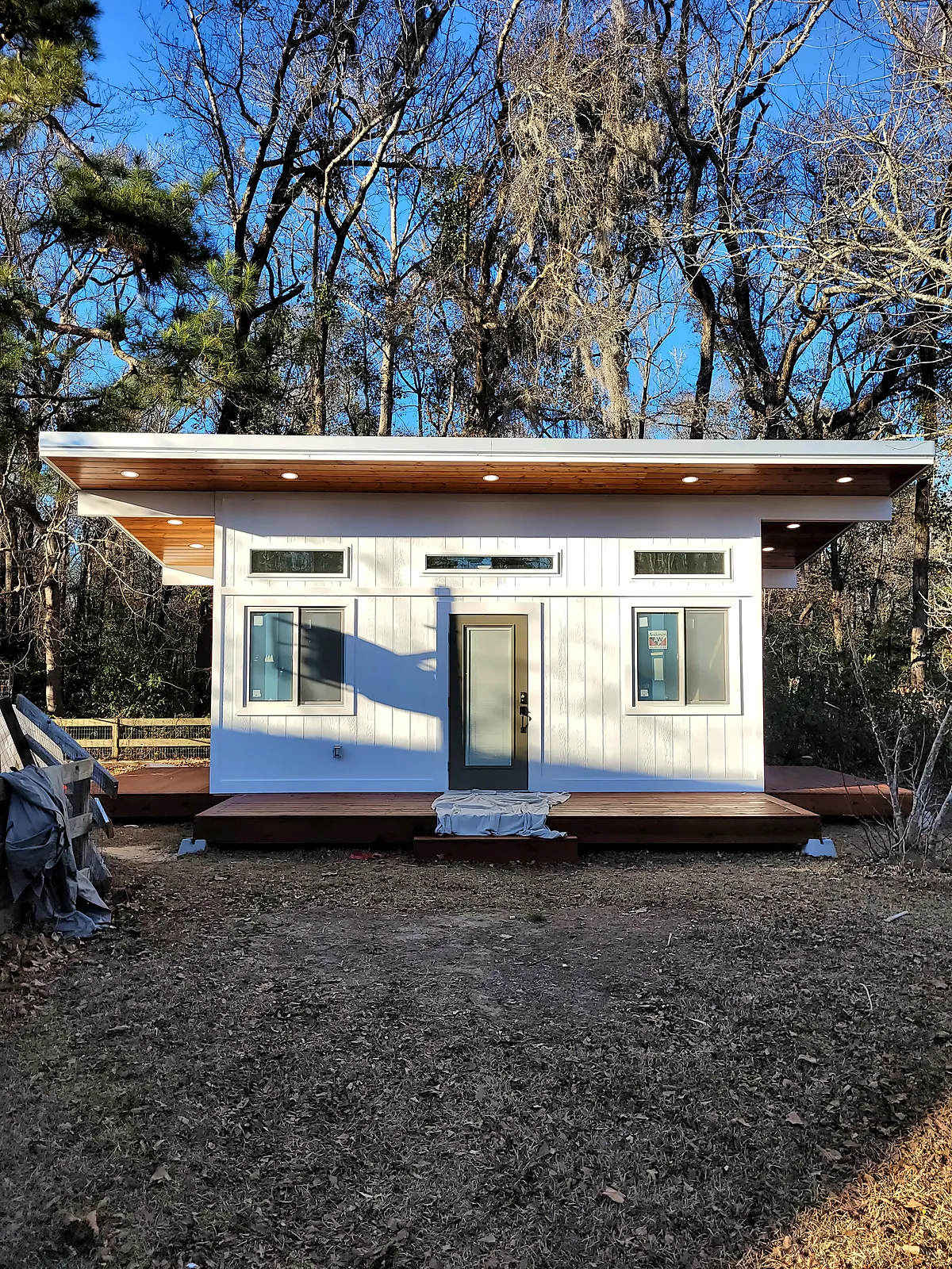Modern backyard studio with shed roof and wood soffit under blue sky