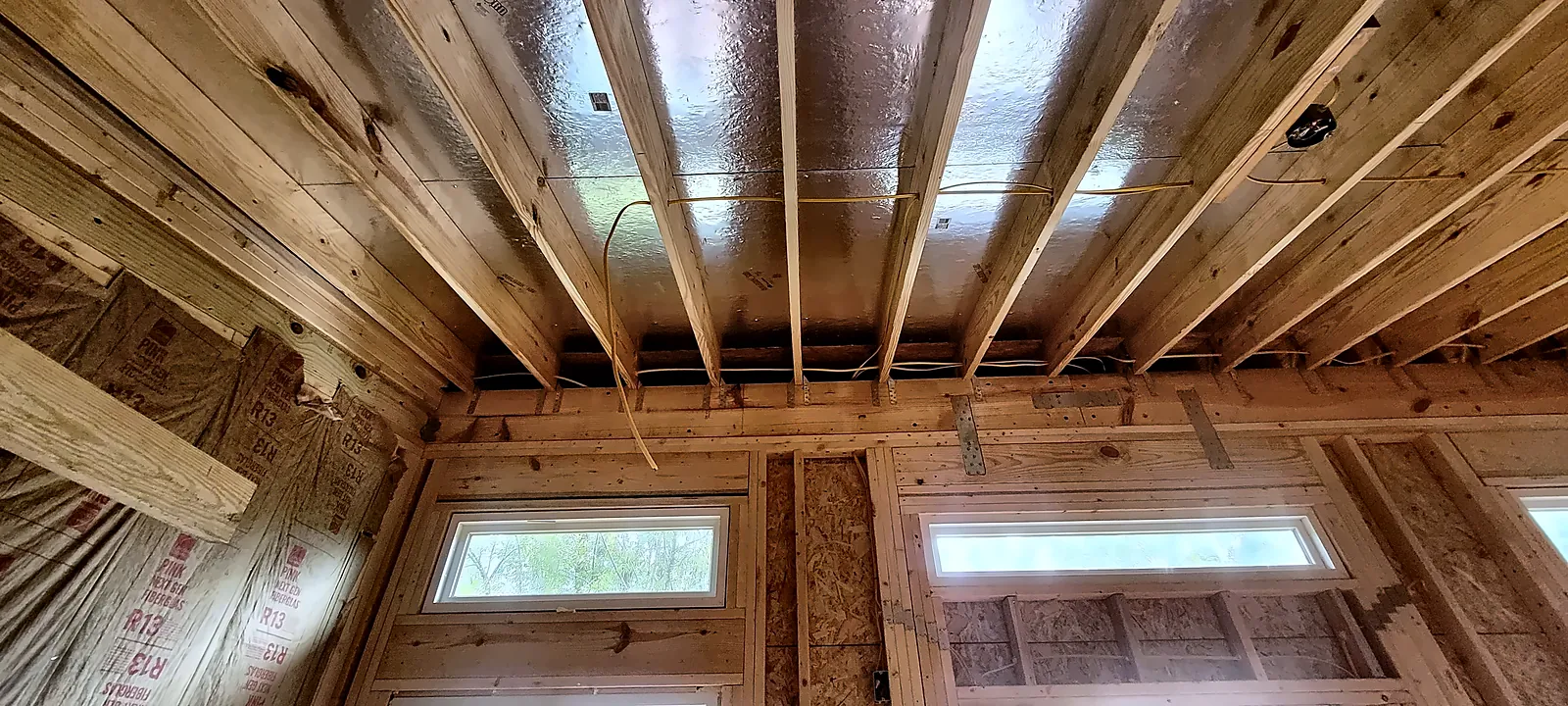 Exposed rafter ceiling and clerestory windows inside backyard studio