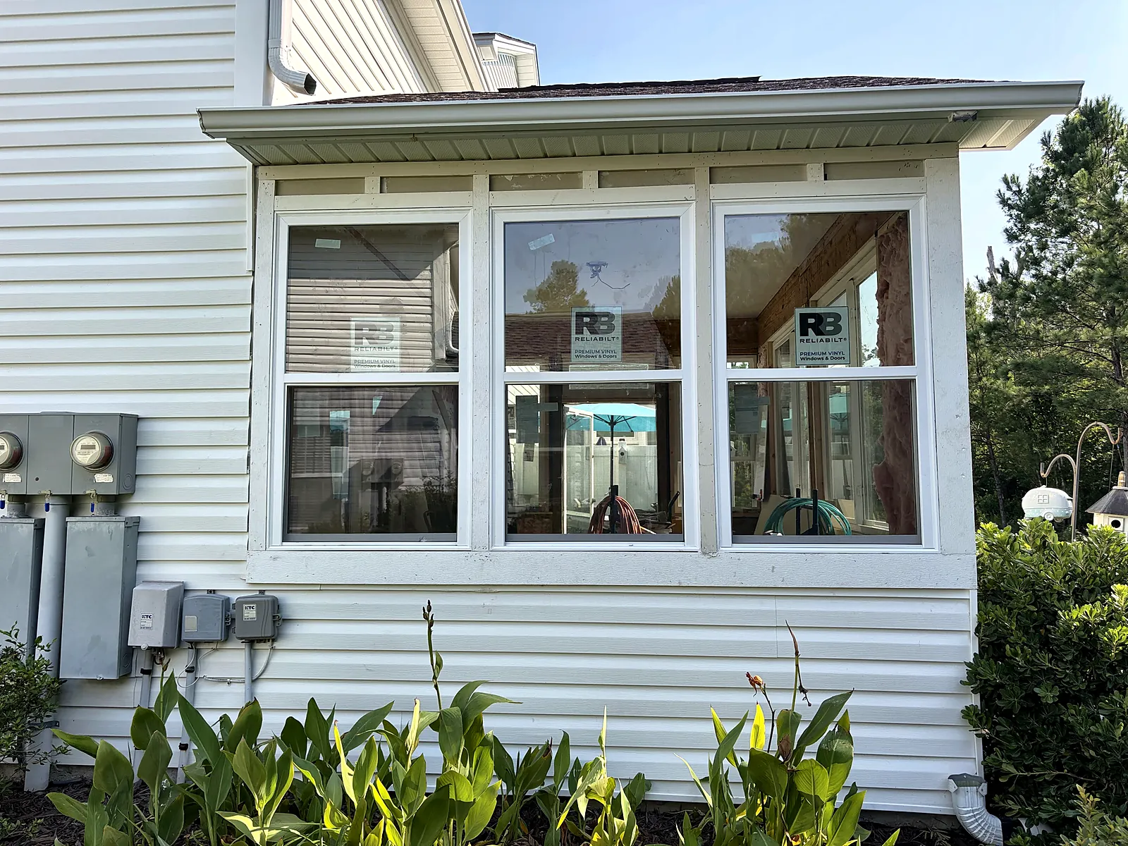Enclosed sunroom exterior with new windows and siding