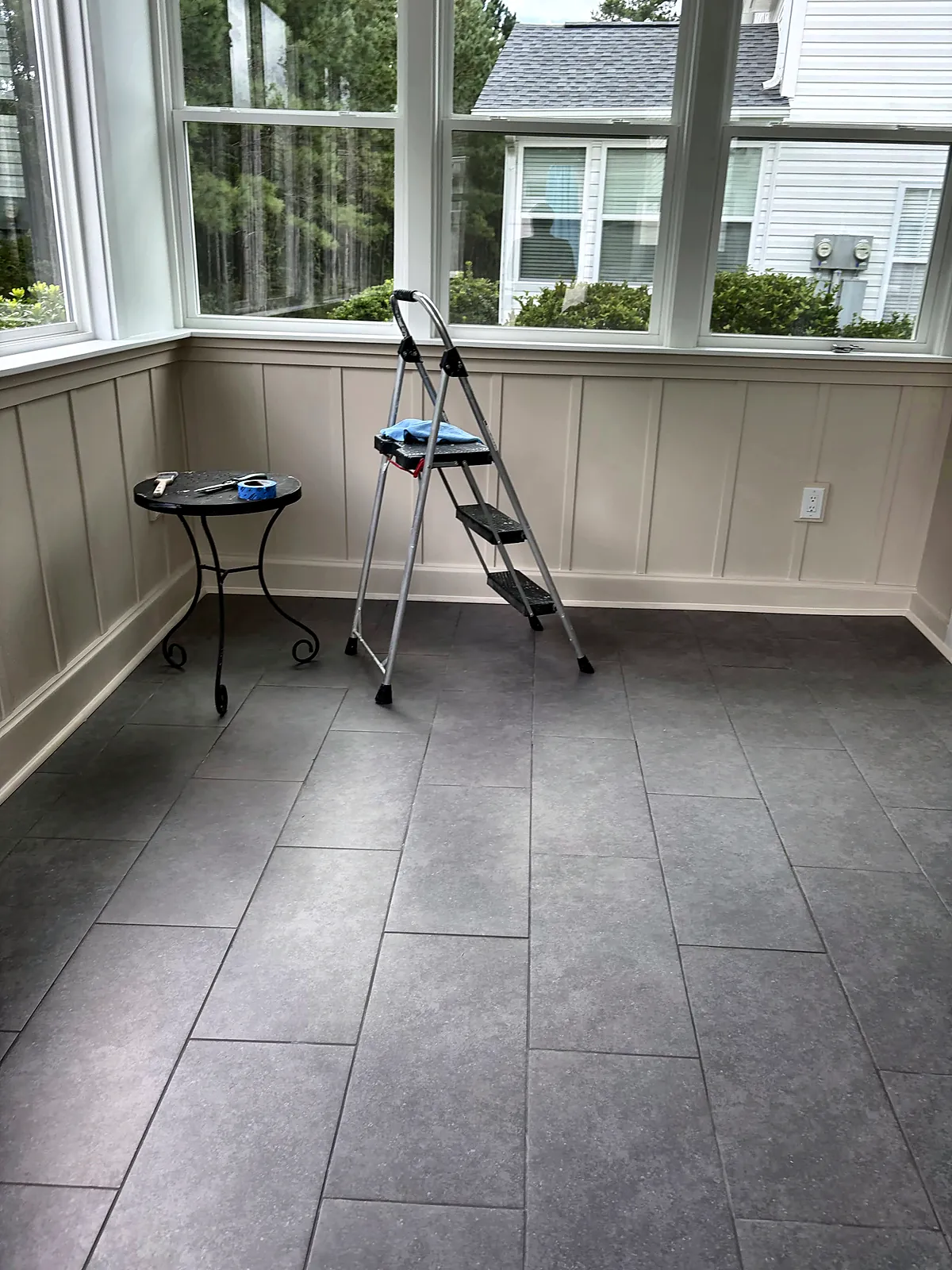 Sunroom with tile floor and wainscot walls