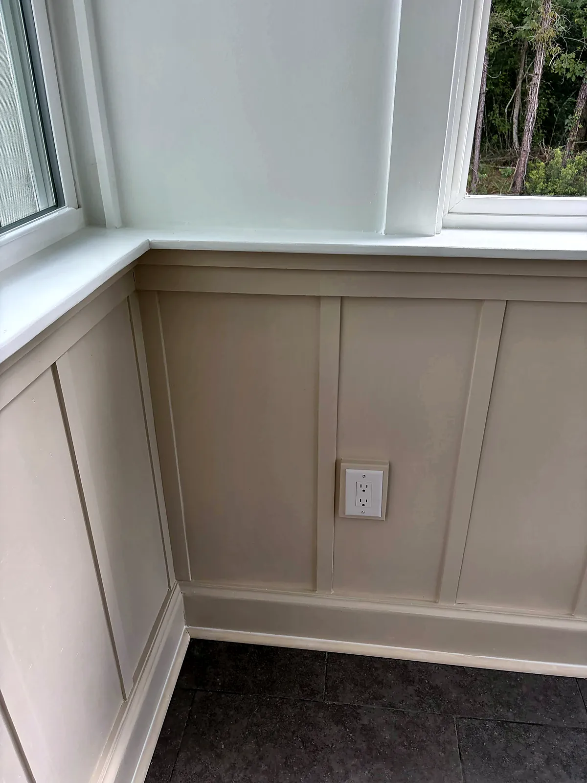 Sunroom corner with wainscot paneling and windows